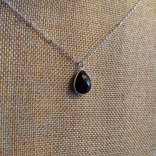One Dainty Faceted Obsidian Teardrop complete on a 16” hypoallergenic shiny stainless steel chain. Obsidian is an igneous rock occurring as a natural glass formed by the rapid cooling of viscous lava from volcanoes. Obsidian was used by early Native Americans and many other primitive peoples for weapons, tools, and ornaments. Ancient Aztec and Greek civilizations used the material for mirrors. Obsidian is a sword against negative energy and a powerful anchor for keeping you grounded in this good life.