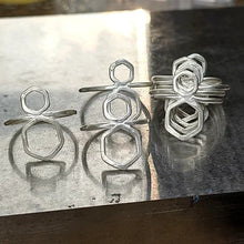 Load image into Gallery viewer, Handcrafted out of solid Argentium Silver, 2  hexagons are fused together to create interesting lines and negative space.   Fusing is a process where I melt the metal just enough to bond with the next piece, creating really strong and clean joints and an interesting molten metal texture.   These are have a shimmery matte finish with a subtle texture left from the hammers and fire.
