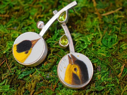A duo of Goldfinch birds in thistle and milkweed seem to be chirping with joy to find some juicy seeds. Hand-cut vintage Audubon porcelain and glistening garnets are set in fabricated sterling silver. Post backs.  Length: 1 -7/8 inches Width: just over 3/8 inch