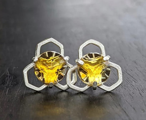 Radiant Citrines are set atop a fused honeycomb structure with a shimmery molten metal texture. Entirely handmade, these are created by fusing and forming the argentium silver many times before they form the honeycomb shape. Argentium is a tarnish resistant alloy of silver, and a lovely molten metal texture is created during the fusing process as well as building up the natural layer of protection on the surface of the metal.   Materials: Argentium Silver  Stones: Citrine