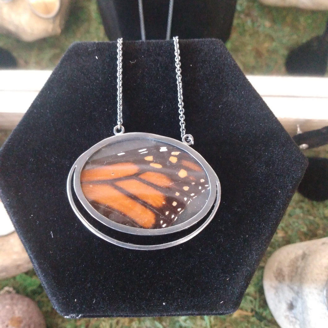 Gorgeous reused Monarch butterfly wings set between two layers of polycarbonate and framed in oxidized sterling silver. Wings are taken apart and reused from an old butterfly wing collection from an estate sale.  Oxidized sterling silver, polycarbonate, Monarch Wing   pendant: 1 1/4