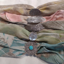 Load image into Gallery viewer, Habotai Silk Scarf is 11&quot; x 11&quot;, hand dyed in a soft, teal color and cinched in the middle with a handmade, Flower charm made of recycled Sterling Silver. Simply knot the scarf at the back of your wrist and you are ready to go!   These botanical bracelets are fun, so comfortable to wear and easily layered with other bracelets. Get ready to receive compliments on this newest trend of jewelry with this earth-friendly Woodland Scarf Bracelet.
