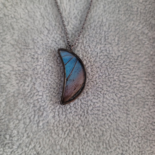 Blue Morpho Crescent Moon Necklace  Materials:  Glass  All necklaces are nickel-free, brass core with a gunmetal finish  Focal metal is lead-free, nickel-free blend of silver and tin  Cruelty free, responsibly sourced butterfly wings