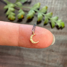 Load image into Gallery viewer, Perfect little crescent moon charm necklace, great for layering or wearing on it’s own. Solid 14k yellow gold moon, on an oxidized sterling silver chain Handmade clasp &amp; catch. Charm moves freely on chain. chain: 17.5” length. charm: 1/4” long Handmade in Colorado with carefully sourced materials.
