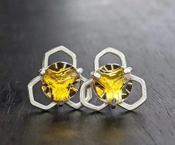 Radiant Citrines are set atop a fused honeycomb structure with a shimmery molten metal texture. Entirely handmade, these are created by fusing and forming the argentium silver many times before they form the honeycomb shape. Argentium is a tarnish resistant alloy of silver, and a lovely molten metal texture is created during the fusing process as well as building up the natural layer of protection on the surface of the metal.   Materials: Argentium Silver  Stones: Citrine