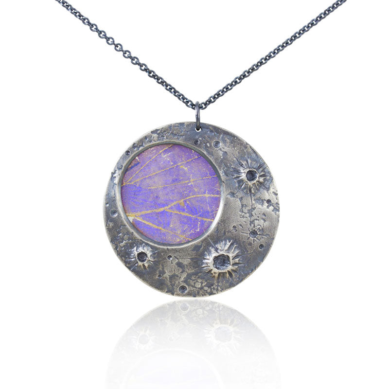 Real blue morpho butterfly wing set in a beautifully textured moon-crater pendant. Sterling silver moon & earwires, morpho wing with a dusting of mica set between two layers of polycarbonate. When worn, pendant shimmers from iridescent blue & purple to flashes of gold. Avoid getting pendant wet (will distort wing color).  pendant: 1.25” diameter  chain: 16”- 18” adjustable  Handmade in Sonoma County with carefully sourced materials.