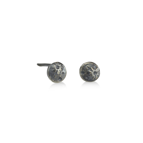 Tiny Moon studs are perfect for everyday wear. Silver moons with crater/moon texture. Standard post & ear nut, all solid sterling silver  Tiny stud, 5mm across  Oxidized silver   third shows sizes of moon studs, Tiny Moon Stud is on left. photo on model, Tiny Mood Stud is in second piercing  Handmade in Colorado using responsibly sourced materials