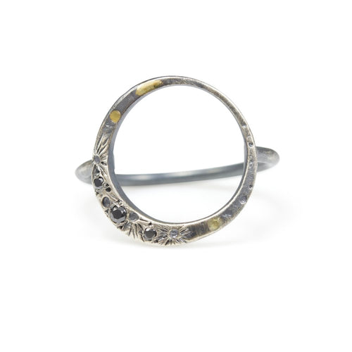 A lyrical moon with three black diamonds and 18k details wraps perfectly around the finger to keep the moon close to you every day. Textured with tiny craters and details.  • 18k yellow gold details • Three black diamonds  Moon is 5/8” Ring is just over 1/2” at tallest point.  This ring is made to order, please allow 2-3 weeks for it to be built to your exact size.  Made in Colorado with carefully sourced materials, including recycled silver and reclaimed black diamonds.