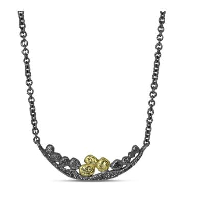 Our wavy bar necklace is evocative of a curving river with an array of signature pebbles created in 18k yellow gold and oxidized sterling silver.  Wear alone or layer with one of our longer chain necklaces!  Metals: 18k yellow gold and oxidized sterling silver  Dimensions: 30 mm wide Chain length: 16”