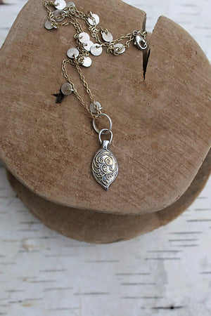 It is handmade by me from raw Sterling Silver and 22kt Genuine Gold accents and reflects the rustic appeal of Italy. It consists of scrolls raised on the surface of a puffed leaf charm that are in the two-toned effect.    It hangs from a 14kt Gold Filled chain with small Sterling discs that have a brushed surface. I offer several lengths to choose from in the menu provided.